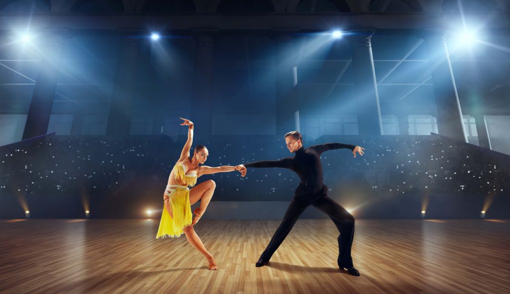 Couple dancers perform latin dance on large professional stage. Ballroom dancing.
