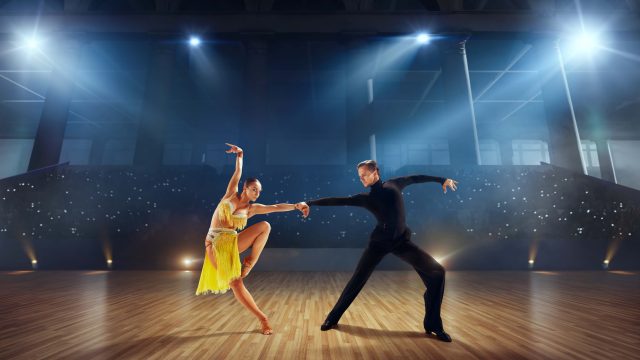 Couple dancers  perform latin dance on large professional stage. Ballroom dancing.